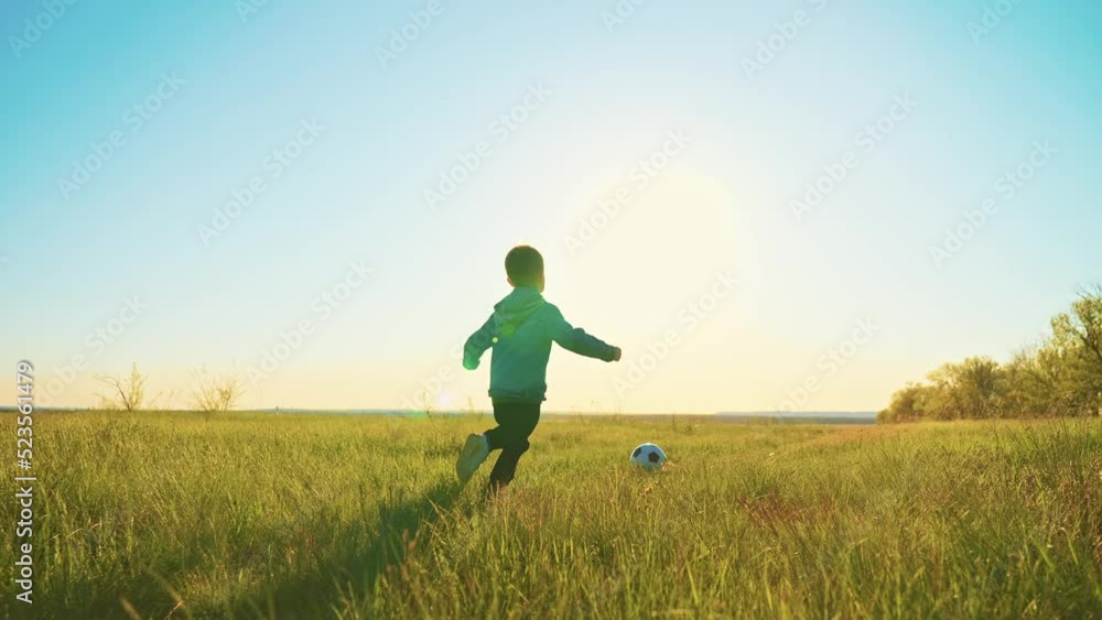 cute little boy is playing football in field in nature in sunny summer day, slow motion, funny preschooler child is running and kicking soccer ball, happy childhood moments cute little boy is playing football in field in nature in sunny summer day, slow motion, funny preschooler child is running and kicking soccer ball, happy childhood moments