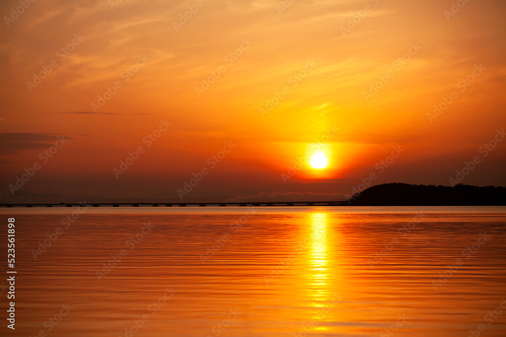 orange sunset on the sea beyond the bridge
