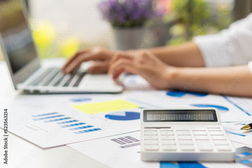 Fototapeta premium Close up hand man doing finance and calculate on desk about cost at home accountant working on desk using calculator for calculate finance report in office