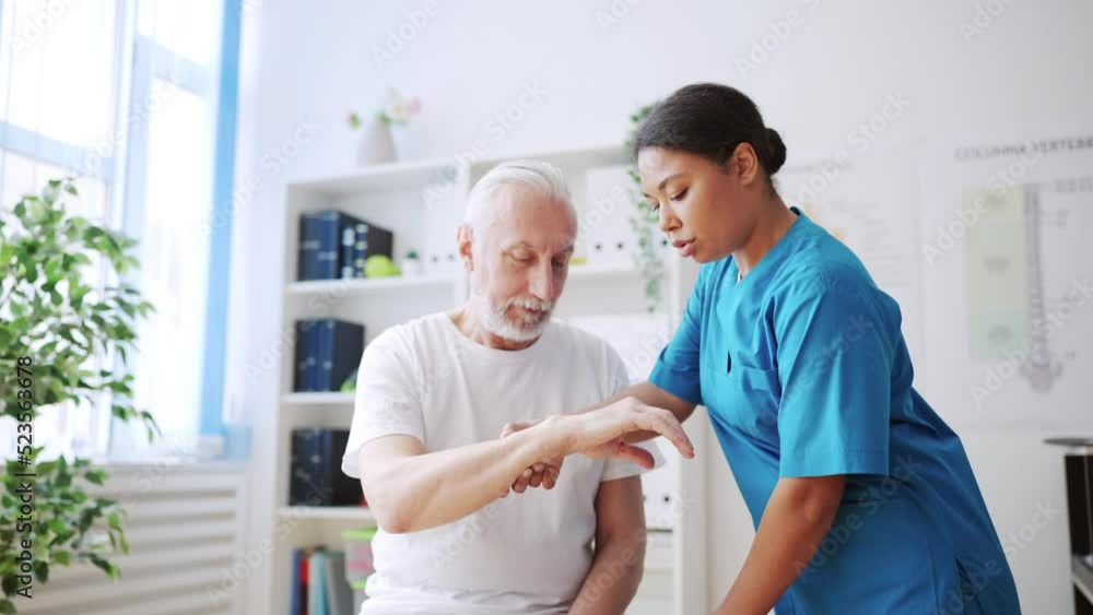 Female doctor removing cast from patient's arm, healed hand, treatment plan Female doctor removing cast from patient's arm, healed hand, treatment plan