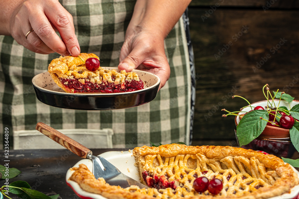 Woman with tasty cherry pie. One piece on a plate and the whole homemade cherry pie