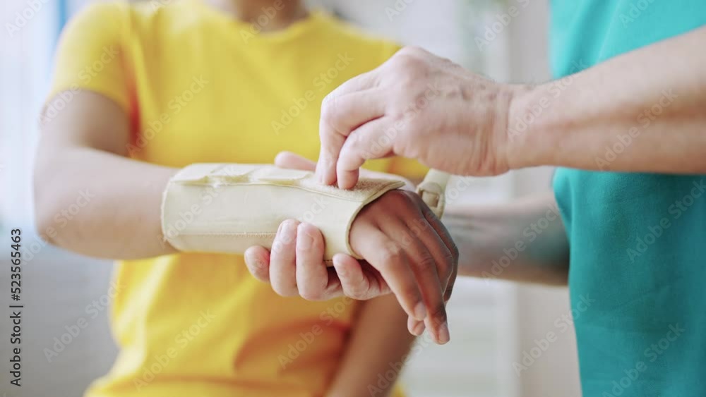 Closeup of traumatologist putting cast on patient's arm, injury treatment Closeup of traumatologist putting cast on patient's arm, injury treatment