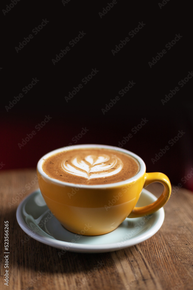 Morning coffee on a wooden table in a beautiful cup with a pattern on the foam. Aromatic coffee in a cafe. Morning coffee on a wooden table in a beautiful cup with a pattern on the foam. Aromatic coffee in a cafe.