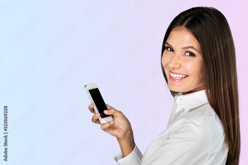 Young smiling cheerful woman hold in hand using mobile cell phone chatting browsing typing sms messaging Young smiling cheerful woman hold in hand using mobile cell phone chatting browsing typing sms messaging