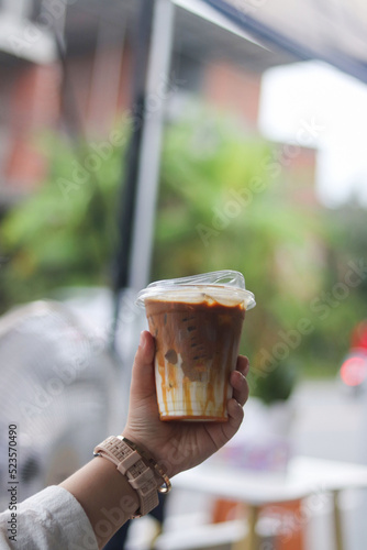 Closeup of Iced Caramel Macchiato at the coffee shop, Caramel Macchiato is a classic macchiato beverage. It consists of vanilla syrup, espresso, steamed milk, foam, and caramel drizzle