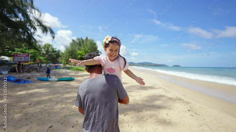 Happy Asian family on summer vacation. Grandfather carrying and playing with little grandchild girl walking on the beach in sunny day. Senior man and child girl kid enjoy outdoor lifestyle at the sea