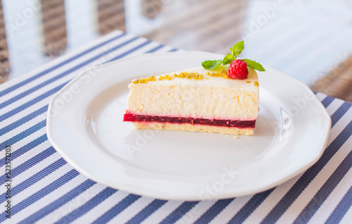 dessert cheesecake on a plate with raspberries in a restaurant with a leaf of mint