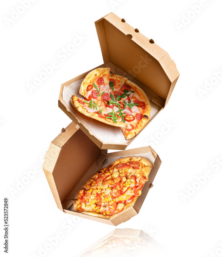 Two baked pizza with in a cardboard boxes in the air on a white background