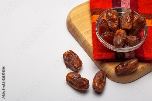 Bowl of pitted dates isolated on white background, top view
