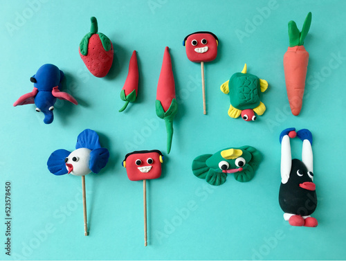 Various colorful models of animals and fruits made by kids using soft clay dough. Cute and colorful clay figures made by children.