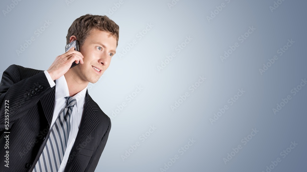 handsome businessman talking mobile phone on the background. handsome businessman talking mobile phone on the background.