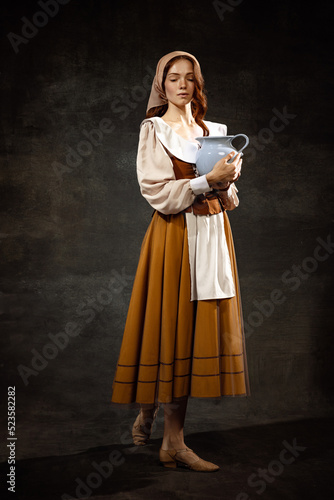 Εκτύπωση καμβά Vintage portrait of young adorable redhead girl in image of medieval person in renaissance style dress isolated on dark background