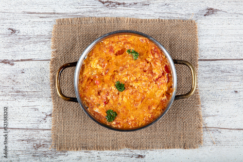 Famous Turkish menemen dinner on table, made by eggs, pepper and tomatoes. Traditional turkish food menemen made by eggs and tomatoes, tea concept background.