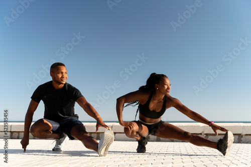 Athlete woman, man doing yoga and stretching body on summer island beach