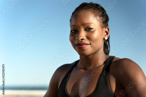 Multiracial woman smiling positively and looking at the camera at the beach