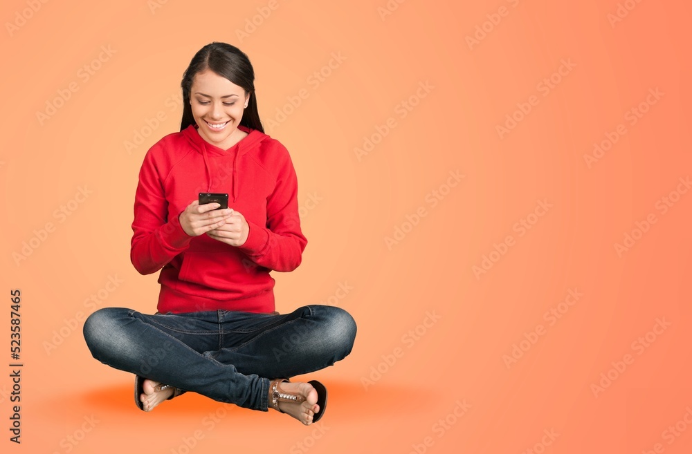 Happy young girl using smartphone on background Happy young girl using smartphone on background
