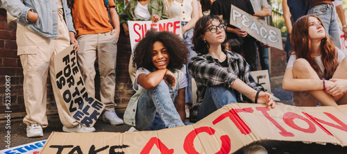 Cheerful teenage girl sitting with a group of youth peace activists