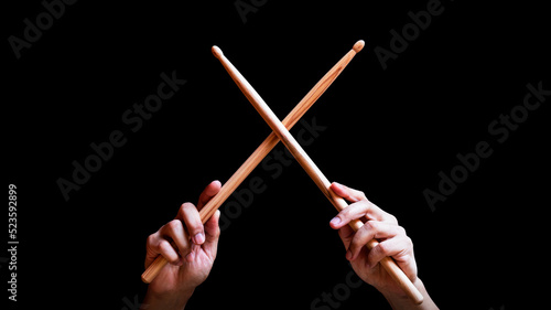 male drummer hands holding drumsticks in x shape. isolated on black photo