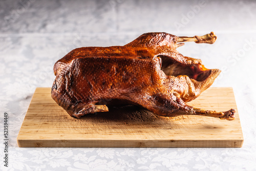 Portioned roast goose on a wooden cutting board - Close up photo