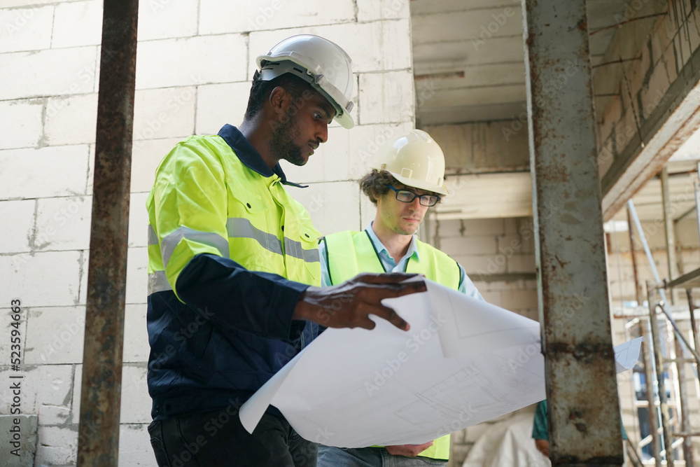 Fototapeta premium Architect and construction engineer or surveyor discussion plans and blueprints