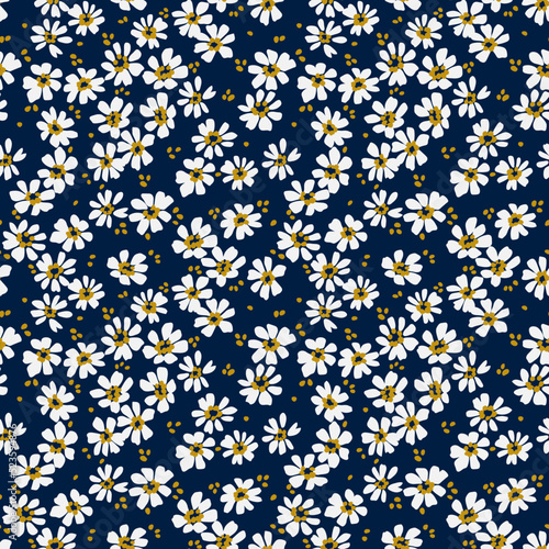 Beautiful floral pattern in small chamomile flowers. Small white flowers. Navy Blue background. Ditsy print. Floral seamless background. The elegant the template for fashion prints. Stock pattern.