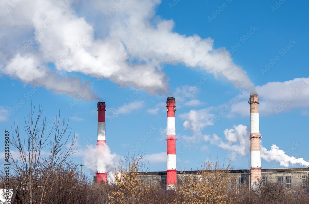 Close-up of the pipes of a thermal power plant with white steam in winter. The concept of environmental pollution and emissions of harmful substances into the atmosphere. Close-up of the pipes of a thermal power plant with white steam in winter. The concept of environmental pollution and emissions of harmful substances into the atmosphere.