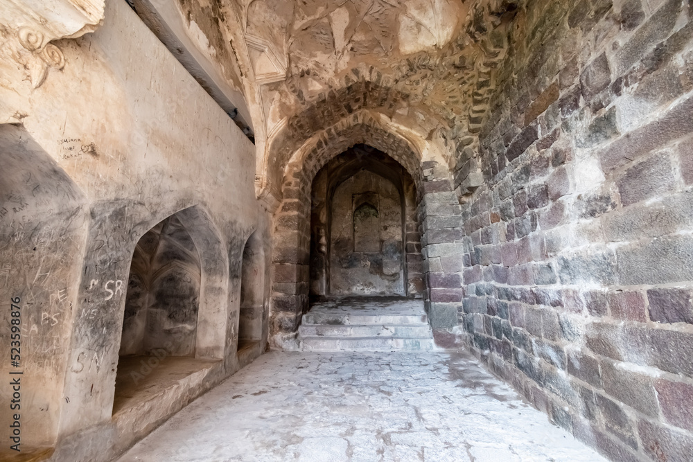 Stone walls and arches in a corridor inside the ruins of the ancient historic Golconda Fort in Hyderabad.