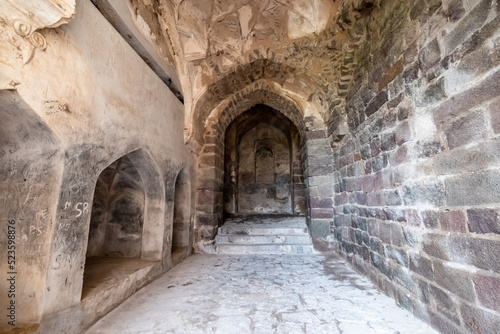 Obraz na płótnie Stone walls and arches in a corridor inside the ruins of the ancient historic Golconda Fort in Hyderabad