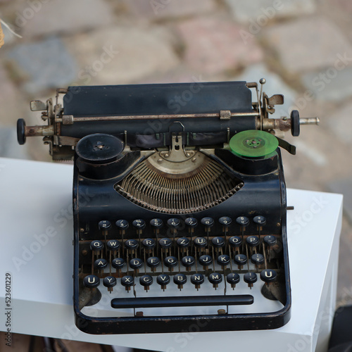 Auf einem Tisch im Freien steht eine alte nostalgische Schreibmaschine.