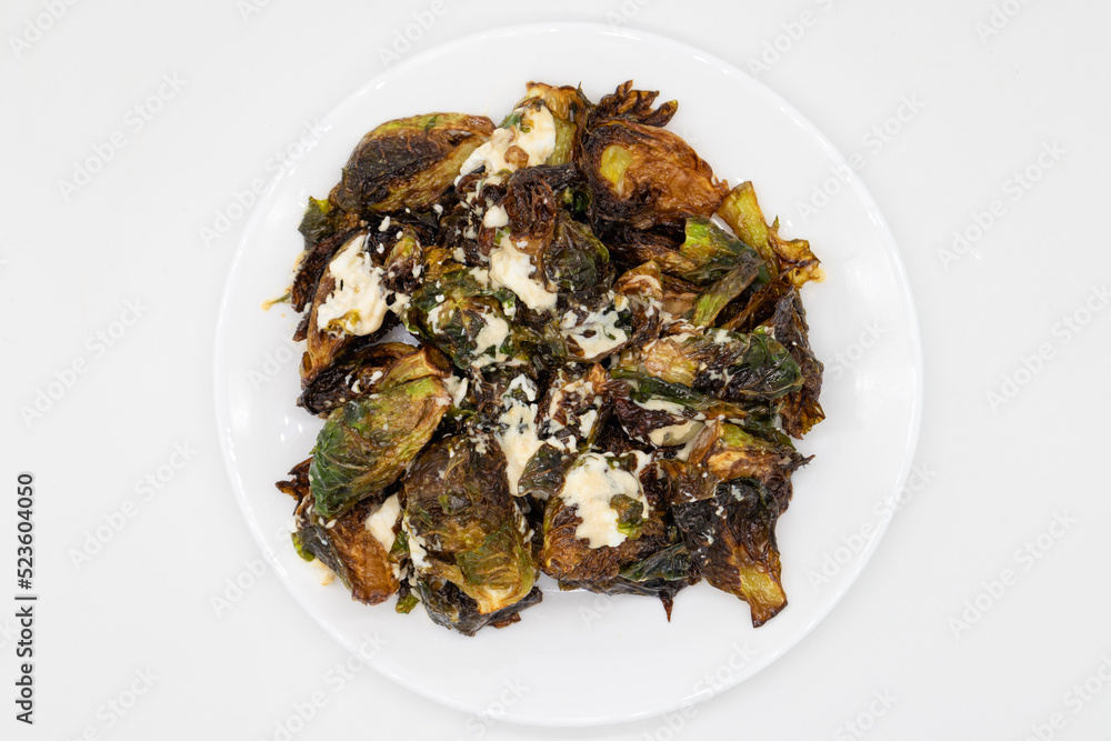 Plate of Crispy Brussels Sprouts with Ricotta Cheese on a White Plate Plate of Crispy Brussels Sprouts with Ricotta Cheese on a White Plate
