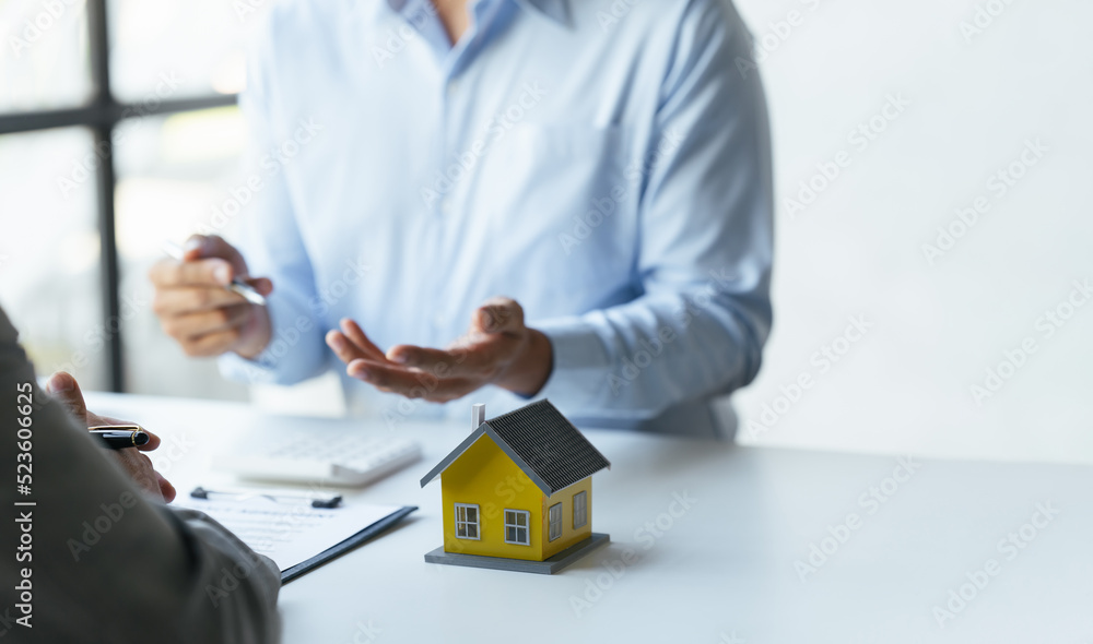Discussion With A Real Estate Agent, a businesswoman signing a contract for Insurance protecting house, a real estate home is pointing to insurance contract signing and are explaining to customers. Discussion With A Real Estate Agent, a businesswoman signing a contract for Insurance protecting house, a real estate home is pointing to insurance contract signing and are explaining to customers.