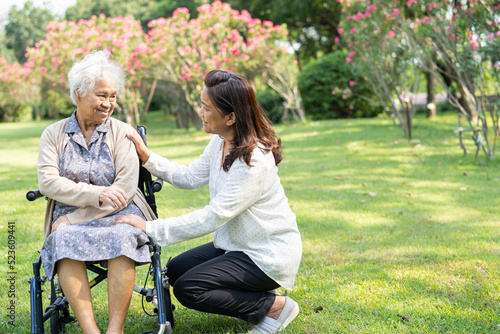 Caregiver help and care Asian senior or elderly old lady woman patient sitting and happy on wheelchair in park, healthy strong medical concept. © amazing studio
