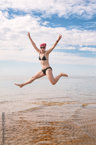 Happy funny woman jumping in the water of sea