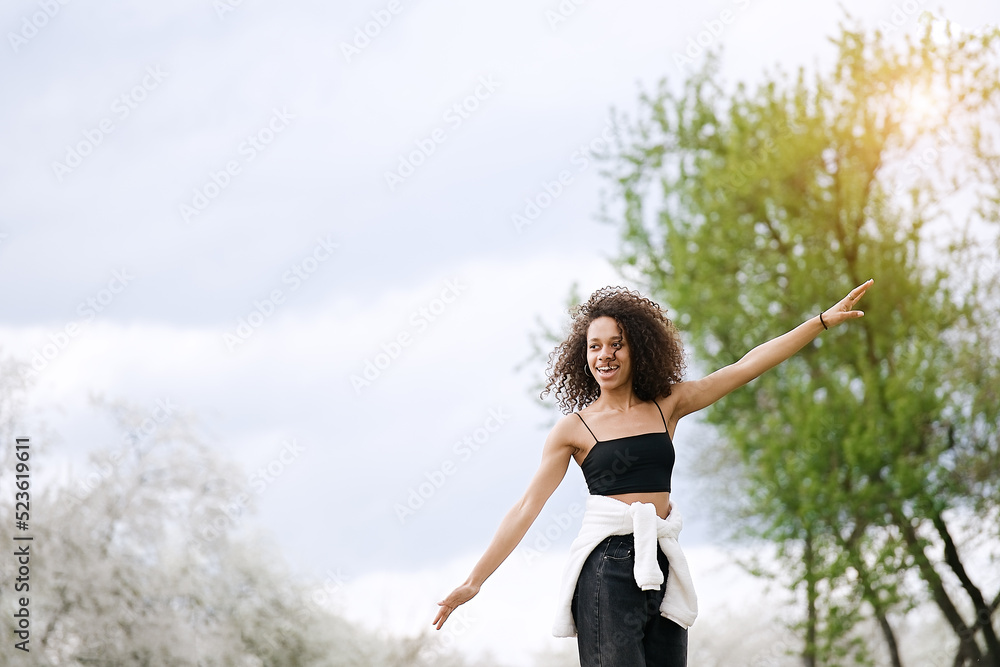 Young african american  woman riding on the skateboard on the road in the park