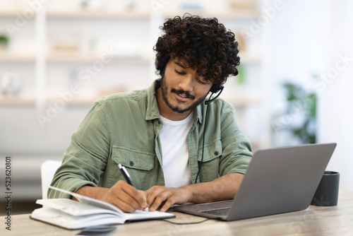 Young indian man having online training, home interior