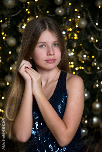 portrait of a beautiful girl with long blond hair near christmas tree
