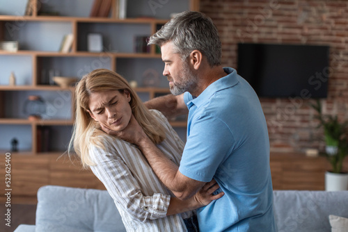 Konstfotografi Aggressive angry european husband strangles behind proud frightened afraid wife