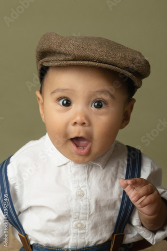 Cute funny baby dressed up like a newsboy 