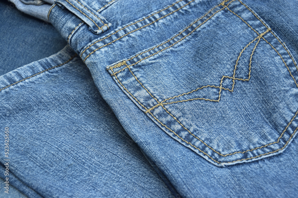 Fototapeta premium Lots of jeans pants in a stack. Denim background.