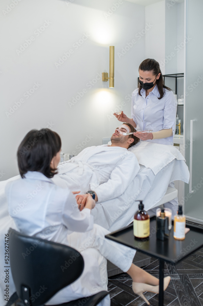 Fototapeta premium Young man having procedures in the cosmetological salon