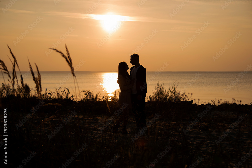 ilhouette of a couple on the beach at sunset