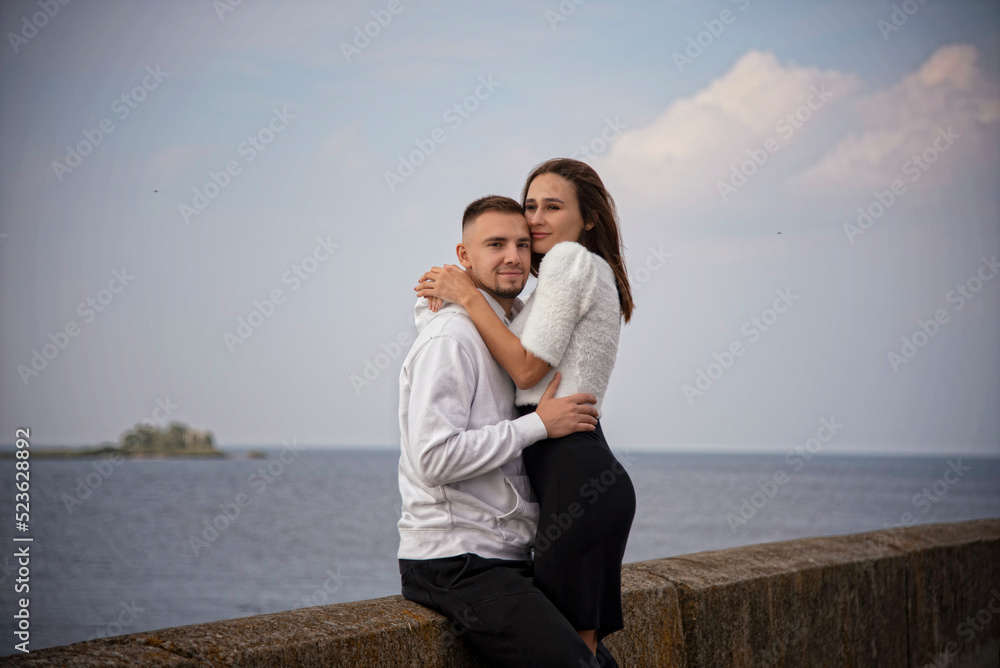 beautiful young couple in white and black dress hugging on the beach beautiful young couple in white and black dress hugging on the beach