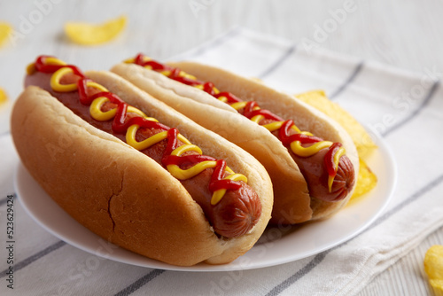 Obraz na płótnie Homemade Hot Dog with Ketchup and Yellow Mustard with Chips on a Plate, low angle view