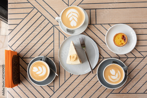 Photography Cappuccino cups and sweets on the wooden table