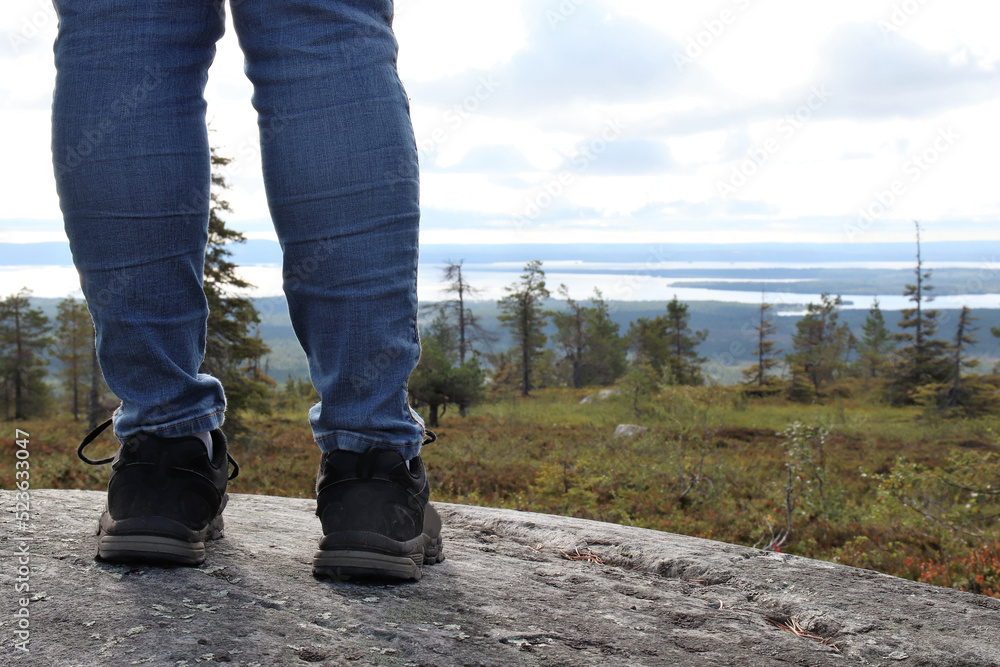 Person hiking in the mountains with hiking boots. The photo is taken in Riisitunturi mountain, which is a national park and a popular trekking place. Person hiking in the mountains with hiking boots. The photo is taken in Riisitunturi mountain, which is a national park and a popular trekking place.