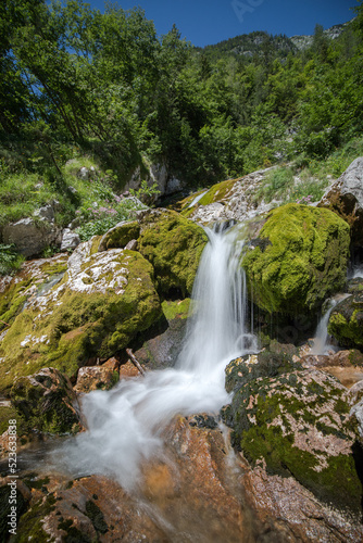 a waterfall between moss-covered boulders at the source of the So  a River