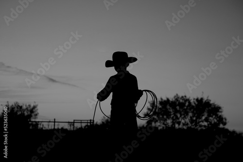 Young cowboy for western silhouette on ranch lifestyle with rope for rodeo industry.
