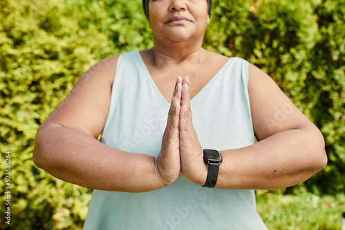 Close up of overweight mature woman holding hands together and medtating outdoors, copy space