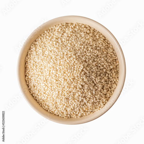 Top view of white sesame seeds in a beige bowl cutout. Raw organic grains on a plate isolated on a white background. Sesamum indicum crop for boosting immunity diet and as calcium source.