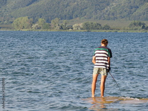 Pescatore intento a pescare sopra un pontile - Fisherman intent on fishing on a jetty